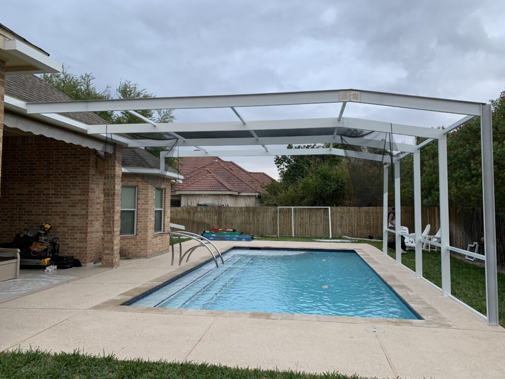 Custom screened pool enclosure over a backyard swimming pool