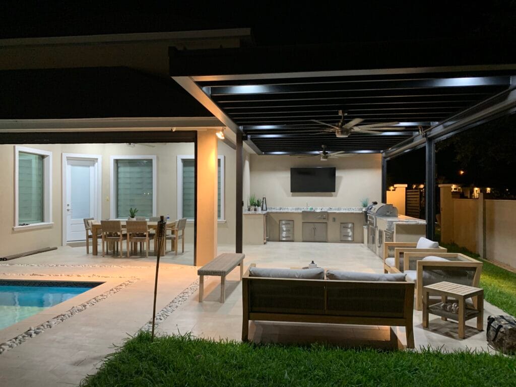 Poolside outdoor kitchen with a grill and seating in Sugar Land, TX