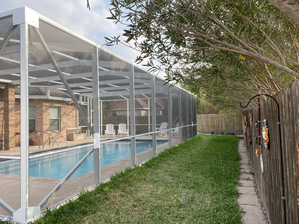 Custom screened pool enclosure over a backyard swimming pool