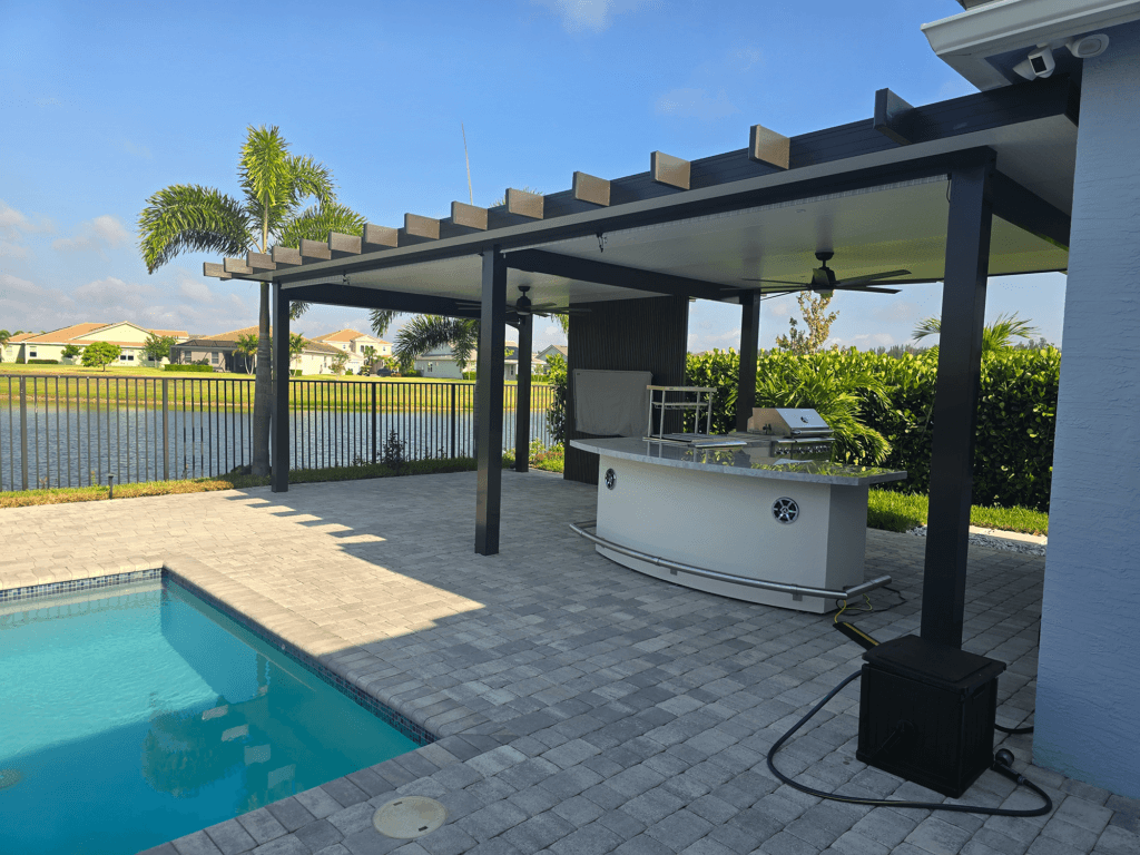 Outdoor kitchen island with bar seating under a patio cover in Houston, TX